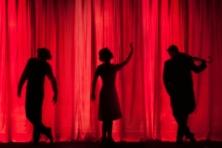 red theatre curtain silhouetted actors